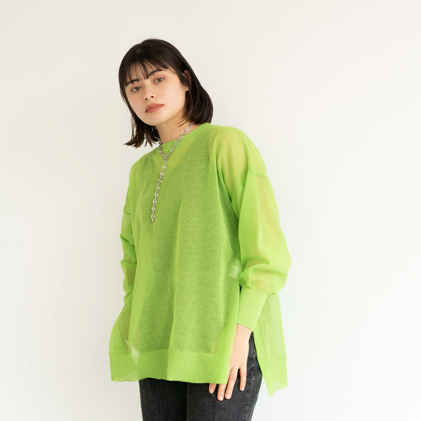 Semi-sheer crew neck pullover knit top with a slightly longer fit.